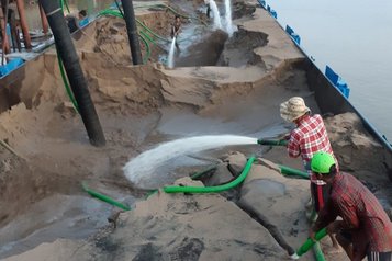 Arbeiter beim Entladen eines Sandkahns